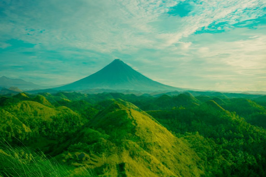 Peaceful mountain landscape with rolling hills under a radiant sky symbolizing spiritual awakening, peace, and personal transformation.